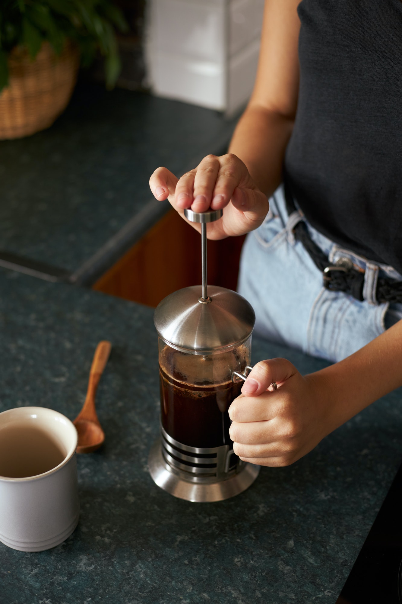 Cropped shot of woman making a cup of coffee